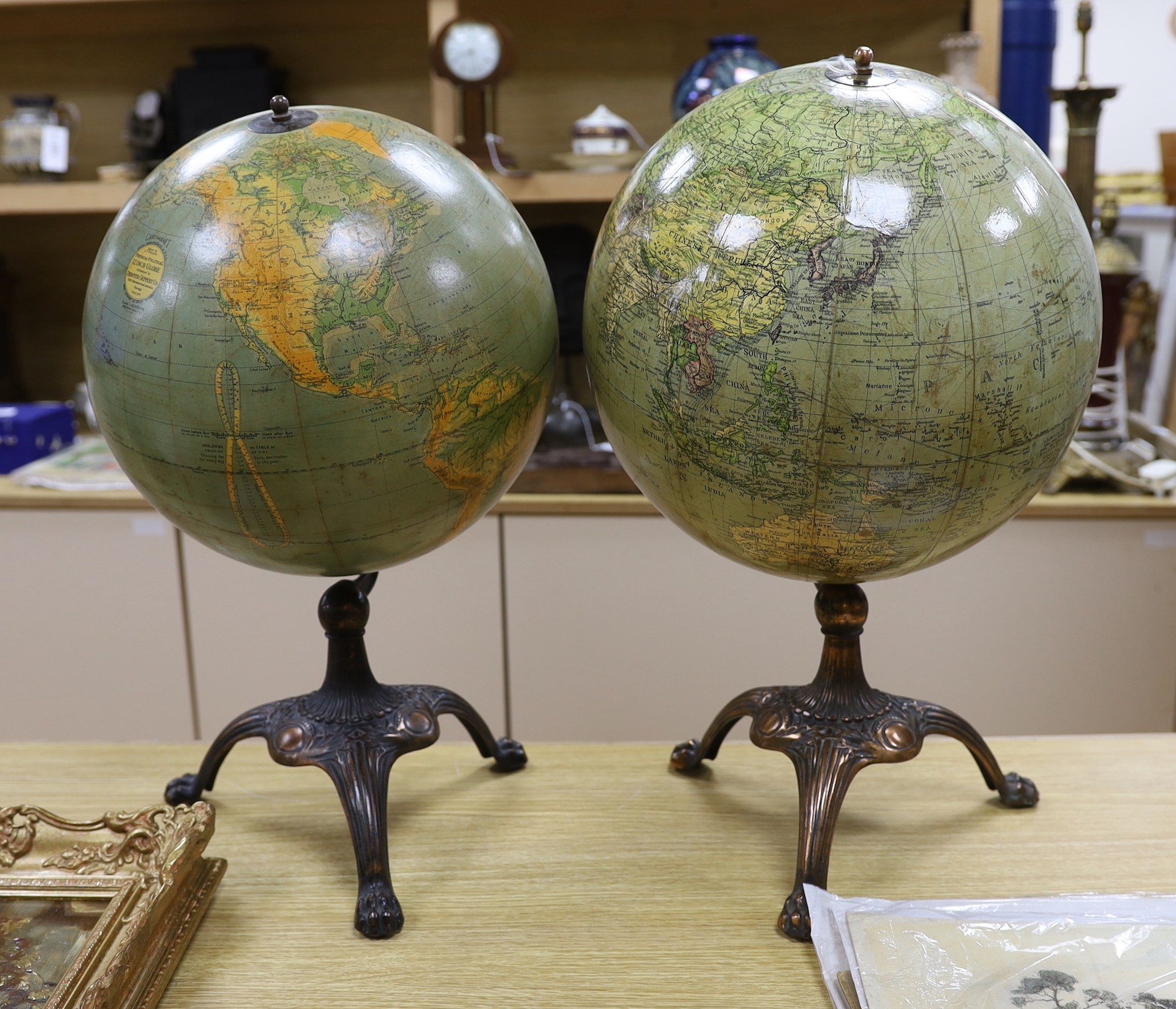 A Cartocraft USA globe on stand and another similar globe on stand, tallest 52cms high